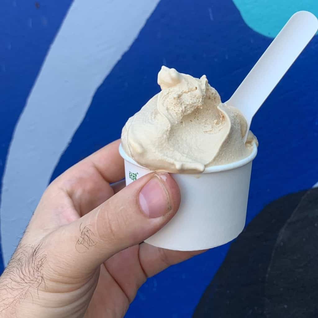 gelato in cup with spoon with blue backdrop